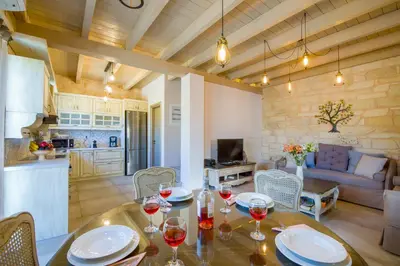 a kitchen and a dining room with a table with wine glasses at Villa Sirocos in Stalos