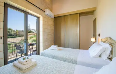 a bedroom with two beds and a balcony at Villa Sirocos in Stalos