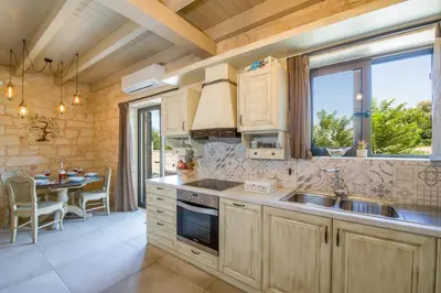 a kitchen with a sink and a table in it at Villa Sirocos in Stalos
