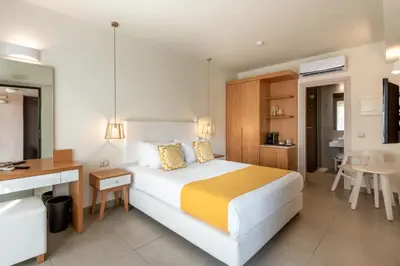 a hotel room with a large bed and a desk at Airis Boutique Hotel & Suites - For adults only in Kato Daratso