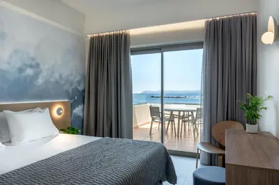 a hotel room with a bed and a view of the ocean at Blue Dome Hotel in Plataniás