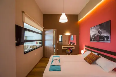 a bedroom with a bed with a red wall at EUPHORIA Luxury Apartment in Chania Town