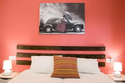 a bedroom with a bed and a painting of a woman with an umbrella at EUPHORIA Luxury Apartment in Chania Town