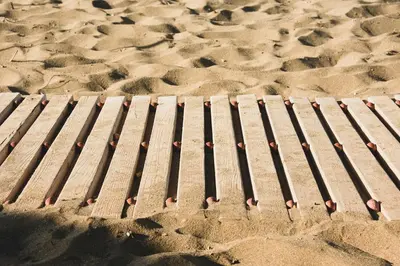 a wooden walkway in the sand on a beach at Ariadne Beach in Plataniás