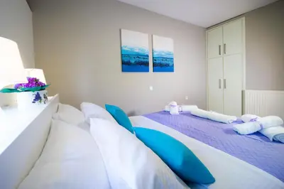 a bedroom with two beds with blue pillows at Rafalia Cozy Apartment in Chania Town