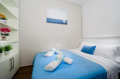 a bedroom with a blue bed with towels on it at Rafalia Cozy Apartment in Chania Town