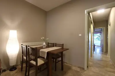 a dining room with a table and chairs and a lamp at Rafalia Cozy Apartment in Chania Town