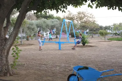 a group of people playing in a park at Dolphin Apartments in Frangokastello