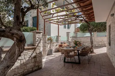 a patio with a table and chairs under a pergola at Antonia Blue Villa in Mourniaí