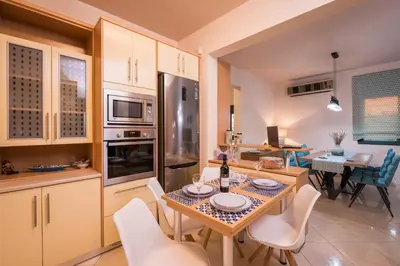 a kitchen and dining room with a table and chairs at Antonia Blue Villa in Mourniaí