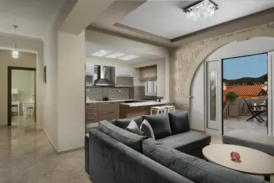 a living room with a couch and a kitchen at Villa Ira in Chorafakia