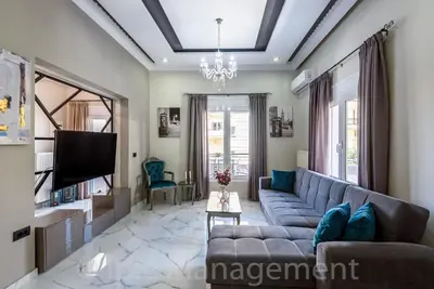 a living room with a couch and a tv at Elegant 2BR Apartment in Chania Town