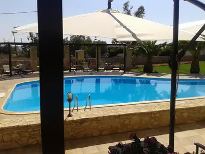 a large swimming pool with an umbrella and anopheemetery at Kallicrates Village in Frangokastello