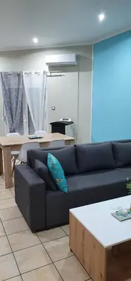 a living room with a black couch and a table at Nina Apartment in Chania Town