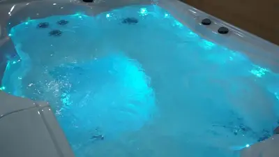 a tub filled with blue water in a bathroom at Nina Apartment in Chania Town