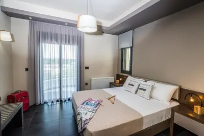 a bedroom with a large bed and a large window at The Hill House Villa in Kato Daratso