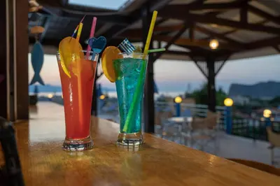 two cocktails sitting on top of a wooden table at Hotel Mimoza in Agia Marina Nea Kydonias