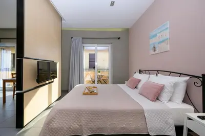 a bedroom with a large bed with a television at You and Me -750m from the sea in Kissamos