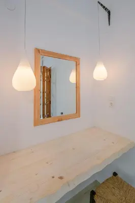 a table with a mirror on a wall with lights at Irtakina in Sougia