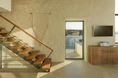 a staircase leading to a living room with a television at Villa Anton by Cura Villas Collection in Kalathas