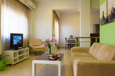 a living room with a couch and a tv at Esthisis Suites Chania in Plataniás