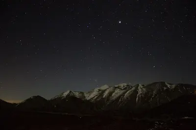 a starry night with the mountains in the background at Esthisis Suites Chania in Plataniás