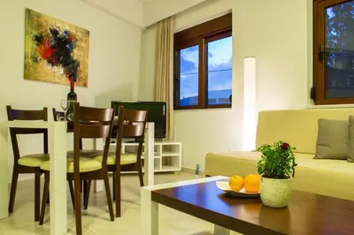 a living room with a table and a dining room at Esthisis Suites Chania in Plataniás