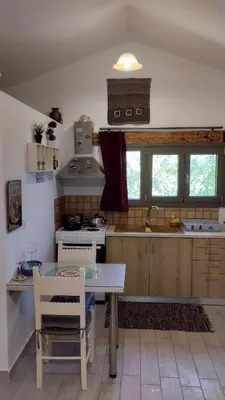 a kitchen with a table and a sink and a stove at Olea Cottage in Galatás