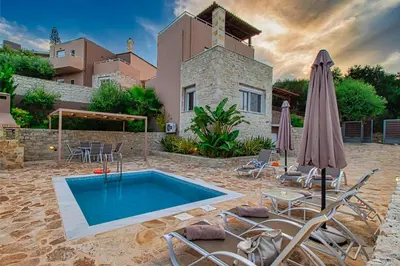 a villa with a swimming pool in front of a house at Theo Villas With Sea View in Marathokefála