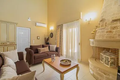a living room with a couch and a fireplace at Theo Villas With Sea View in Marathokefála