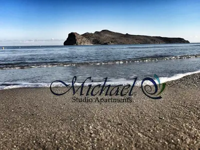 a picture of a beach with a rock in the water at Michael Apartments in Agia Marina Nea Kydonias