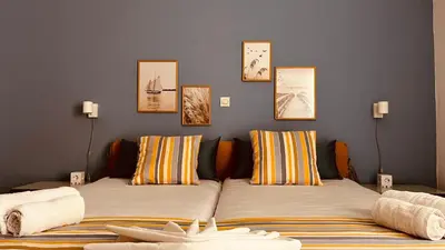 two beds in a room with pictures on the wall at Michael Apartments in Agia Marina Nea Kydonias