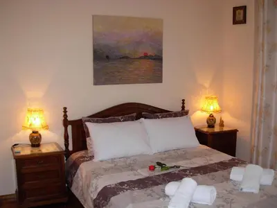 a bedroom with a bed with two lamps and a painting at Michele's Flat in Chania Town