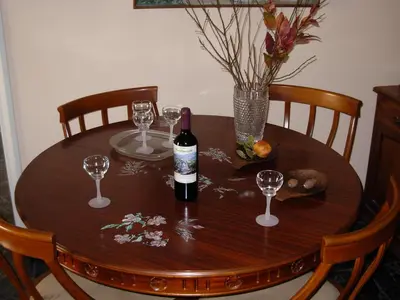 a wooden table with a bottle of wine and wine glasses at Michele's Flat in Chania Town
