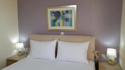 a bed with white pillows and a painting above it at Amazing Sea View Apartment in Chania Town