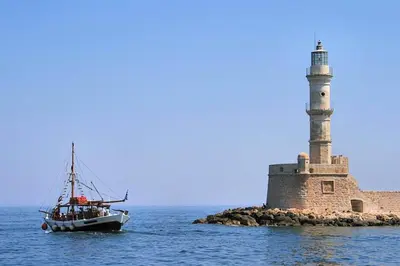 a boat in the water next to a lighthouse at Amazing Sea View Apartment in Chania Town