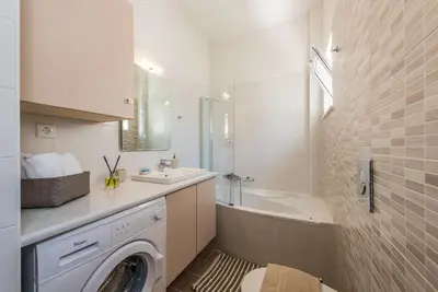 a bathroom with a washing machine and a sink at Villa Neaira in Vatólakkos