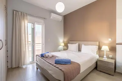 a bedroom with a bed and a large window at Villa Neaira in Vatólakkos