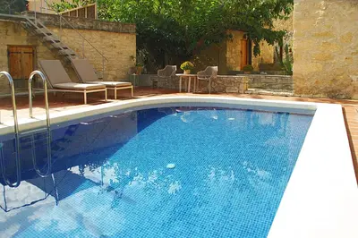a large blue swimming pool with chairs in a yard at Villa Irini - Authentic Cretan Retreat with Private Pool in Vafés