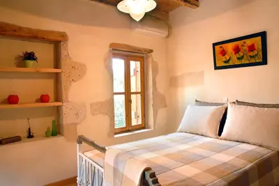 a bedroom with a bed and a window at Villa Irini - Authentic Cretan Retreat with Private Pool in Vafés