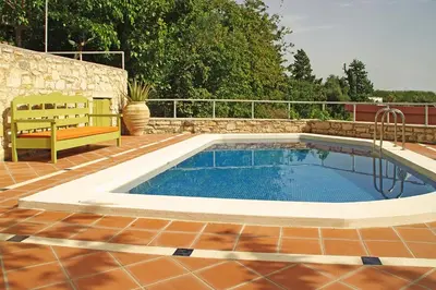 a swimming pool on a patio with a bench next to it at Villa Irini - Authentic Cretan Retreat with Private Pool in Vafés