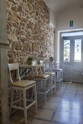 a room with tables and chairs and a brick wall at Vilelmine in Chania Town