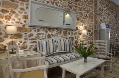 a living room with a couch and a tv on the wall at Vilelmine in Chania Town