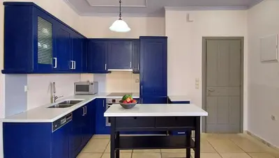 a blue kitchen with a bowl of fruit on a counter at Thealia in Karefilianá