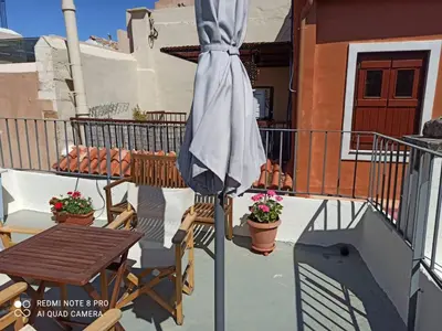 a patio umbrella on a balcony with a table and a table at Casa Topane in Chania Town