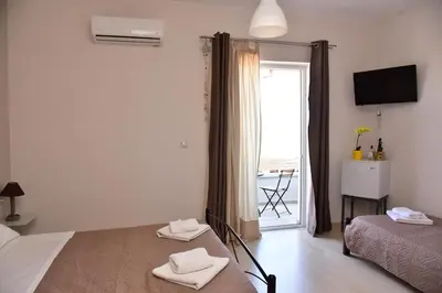 a bedroom with two beds and a window with a view at Rooms Kochilas Elafonisi in Elafonisi