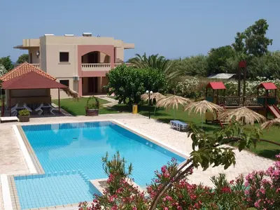 a swimming pool in front of a house at Villa Rita Apartments A in Tavronitis