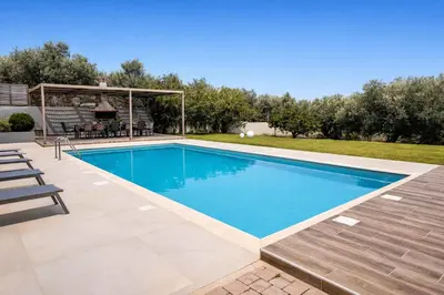 a swimming pool in a backyard with a picnic table and chairs at Villa Aelia I Modern & Ideal for large groups in Galatás