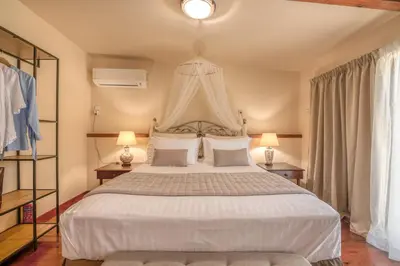 a bedroom with a large white bed with two lamps at Kalliopi's Maisonette in Chania Town