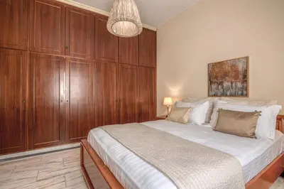 a bedroom with a large bed with wooden cabinets at Kalliopi's Maisonette in Chania Town